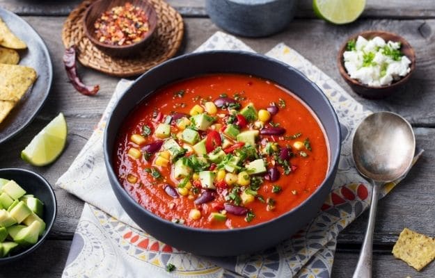 Mexican tomato, bean, bell pepper soup in black bowl. | Vegan Tortilla Soup | 9 Easy Frozen Vegan Meals To Make Ahead