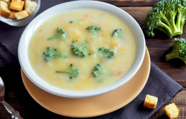 Vegetable and cheese cream soup with broccoli and croutons over wooden background | Vegan Broccoli Cheese Soup | 9 Easy Frozen Vegan Meals To Make Ahead